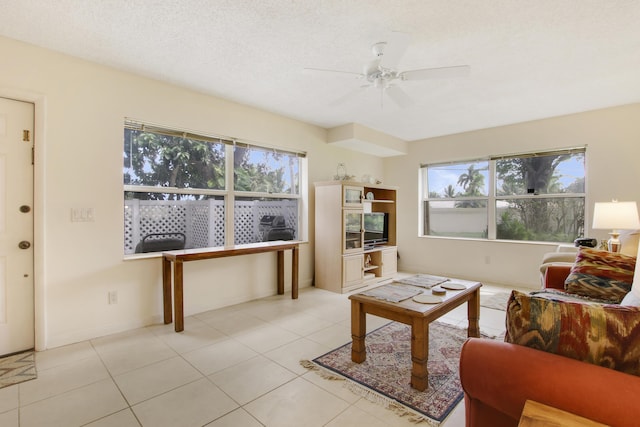 living area featuring a ceiling fan and light tile patterned floors