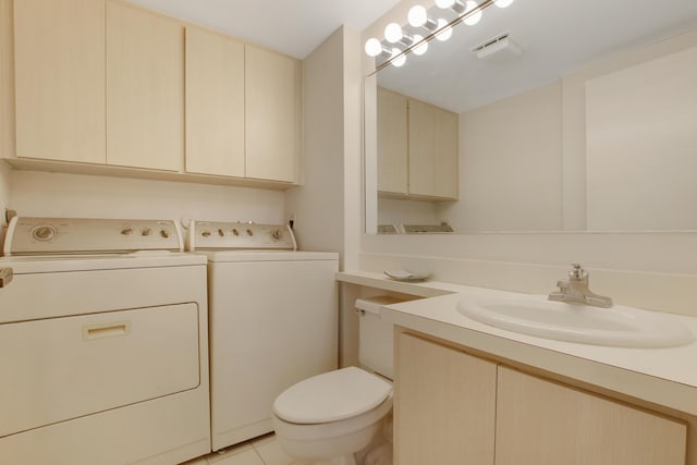 bathroom with washing machine and dryer, toilet, vanity, and tile patterned flooring