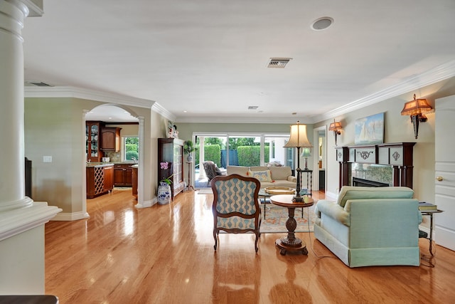 1360 SW Sugar Plum Dr, Boca Raton, FL 33486 - living room with ornate columns, light wood finished floors, arched walkways, ornamental molding, and a fireplace