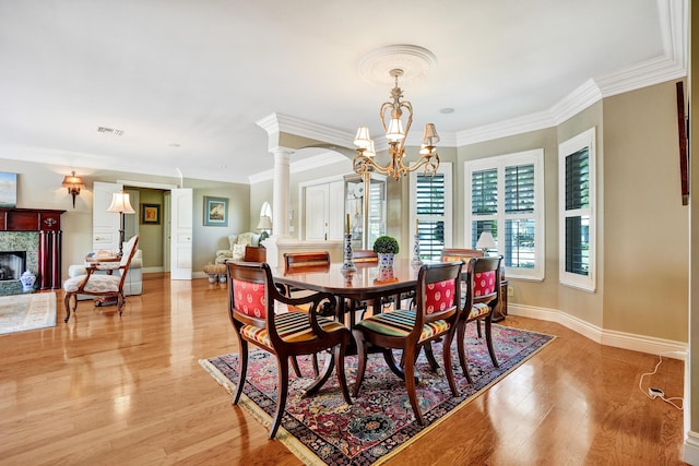 1360 SW Sugar Plum Dr, Boca Raton, FL 33486 - dining area featuring decorative columns, ornamental molding, a high end fireplace, a chandelier, and light wood finished floors