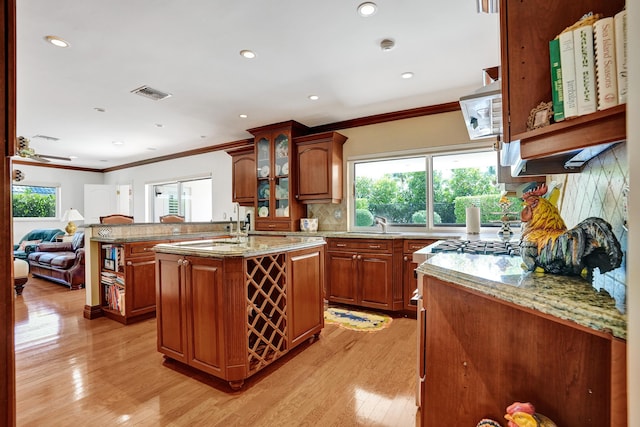 1360 SW Sugar Plum Dr, Boca Raton, FL 33486 - kitchen featuring crown molding, healthy amount of natural light, light wood-style flooring, light stone countertops, and decorative backsplash