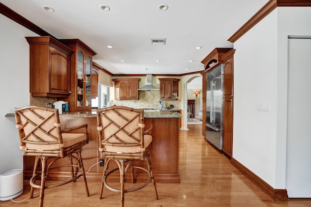 1360 SW Sugar Plum Dr, Boca Raton, FL 33486 - kitchen featuring wall chimney exhaust hood, stainless steel built in fridge, a peninsula, crown molding, and backsplash