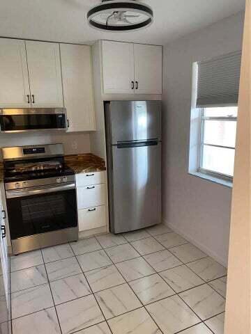 3566 N University Dr Unit F-5, Coral Springs, FL 33065 - kitchen with appliances with stainless steel finishes, white cabinetry, and dark countertops