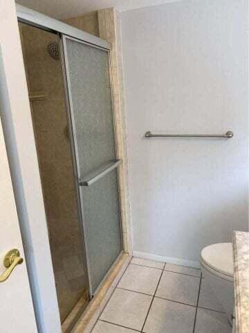 3566 N University Dr Unit F-5, Coral Springs, FL 33065 - bathroom featuring a stall shower, tile patterned floors, and toilet