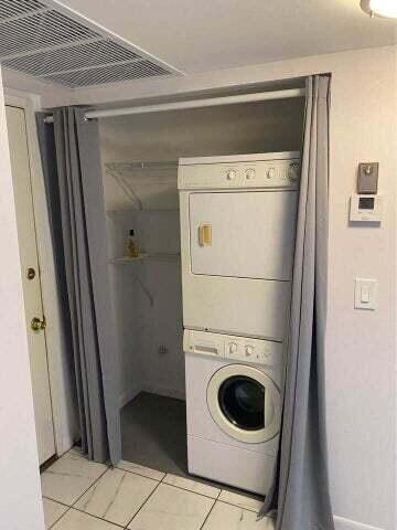 3566 N University Dr Unit F-5, Coral Springs, FL 33065 - clothes washing area featuring stacked washer / drying machine and light tile patterned floors