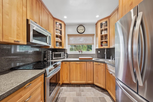 520 NE 7th Ave Unit 2E, Delray Beach, FL 33483 - kitchen with stainless steel appliances, a sink, recessed lighting, glass insert cabinets, and tasteful backsplash