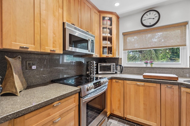 520 NE 7th Ave Unit 2E, Delray Beach, FL 33483 - kitchen with stainless steel appliances, tasteful backsplash, glass insert cabinets, and recessed lighting
