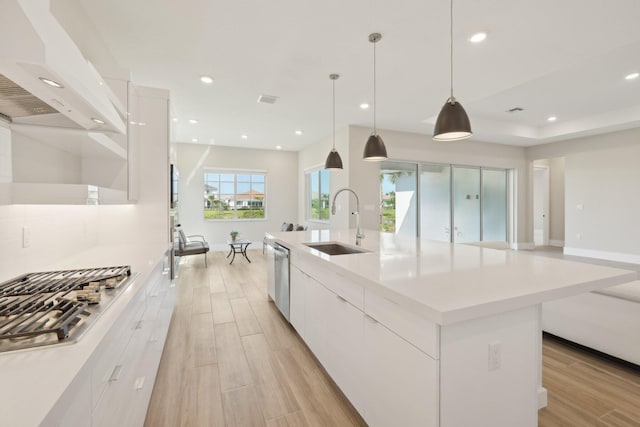 kitchen with modern cabinets, appliances with stainless steel finishes, a sink, white cabinets, and recessed lighting