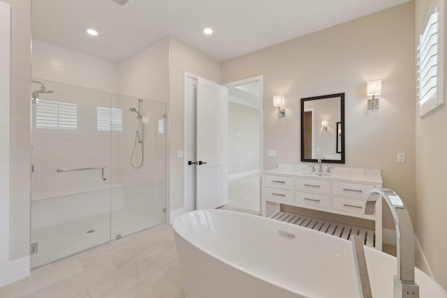 bathroom with a stall shower, a freestanding bath, vanity, and recessed lighting