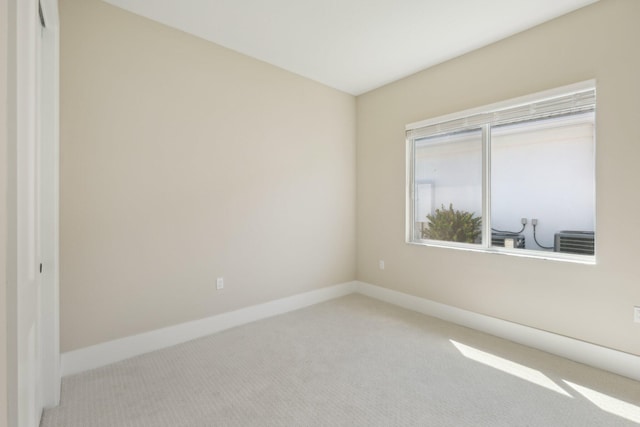 carpeted spare room featuring baseboards