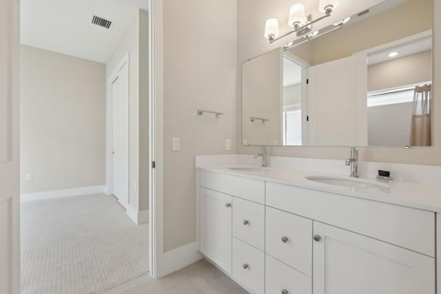 full bath featuring double vanity, tile patterned flooring, and baseboards