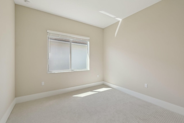 carpeted spare room featuring baseboards