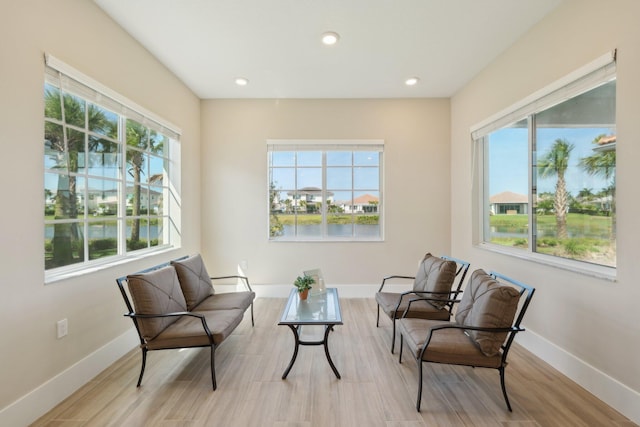 living area with plenty of natural light, wood finished floors, recessed lighting, and baseboards