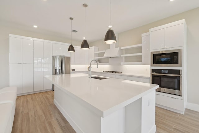 kitchen featuring appliances with stainless steel finishes, a sink, modern cabinets, white cabinetry, and recessed lighting
