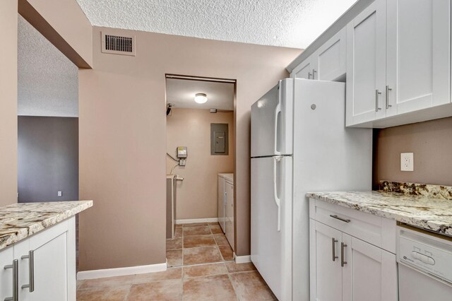 kitchen with washer and clothes dryer, electric panel, a textured ceiling, white appliances, and white cabinets