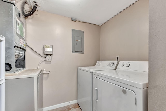 laundry area featuring electric panel, washer and dryer, baseboards, and light tile patterned floors