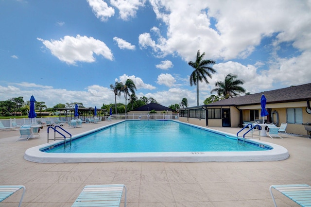 community pool with a patio and fence