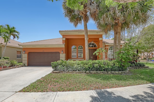 1741 Annandale Cir, Royal Palm Beach, FL 33411 - mediterranean / spanish house featuring a garage, a tile roof, stucco siding, and concrete driveway