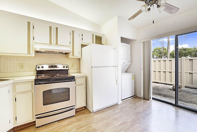 1017 Green Pine Blvd E, West Palm Beach, FL 33409 - kitchen featuring electric stove, freestanding refrigerator, stacked washer / dryer, under cabinet range hood, and vaulted ceiling