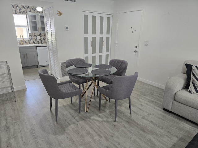 dining space with light wood-style flooring and baseboards