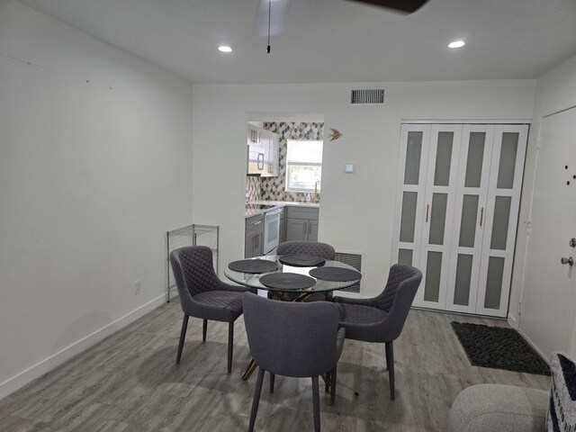 dining space featuring wood finished floors, recessed lighting, and baseboards