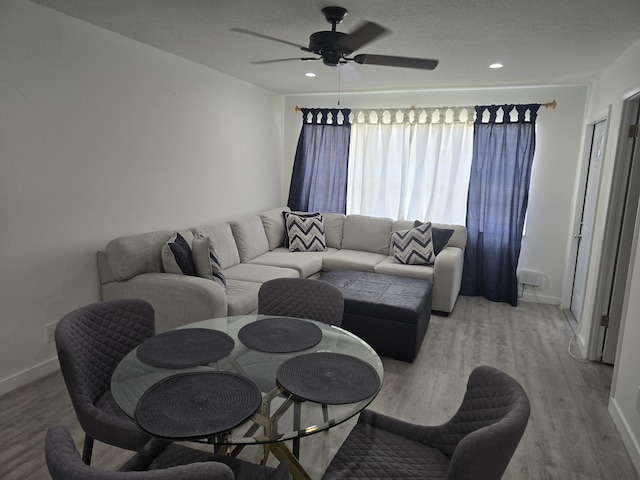 living area featuring a ceiling fan, baseboards, light wood-style flooring, and recessed lighting