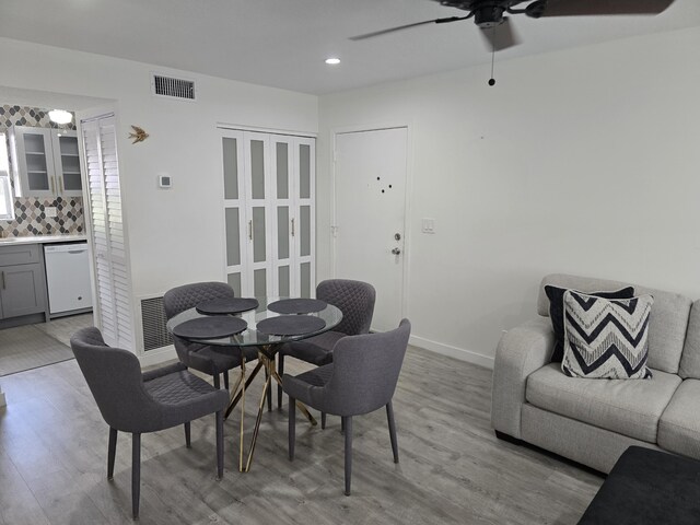 dining space featuring light wood finished floors, a ceiling fan, baseboards, and recessed lighting