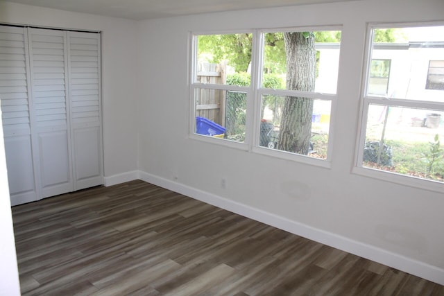 3264 Ocean Pkwy, Boynton Beach, FL 33435 - unfurnished bedroom with baseboards, dark wood finished floors, and multiple windows
