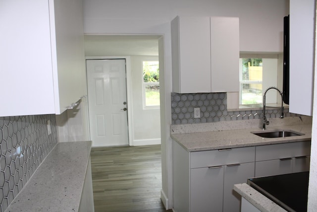 3264 Ocean Pkwy, Boynton Beach, FL 33435 - kitchen featuring a sink, white cabinetry, backsplash, light stone countertops, and plenty of natural light
