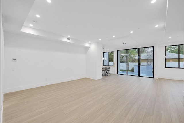 unfurnished room with light wood-type flooring, recessed lighting, and baseboards