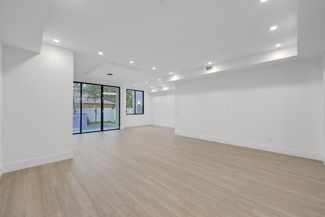 spare room with recessed lighting, baseboards, and light wood-style floors