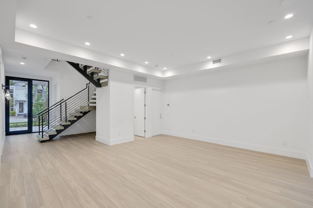 below grade area featuring stairs, baseboards, light wood-style flooring, and recessed lighting