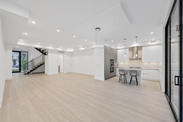 living area featuring stairs, light wood-style flooring, recessed lighting, and baseboards