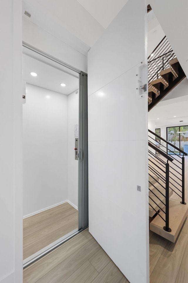 interior space with wood finished floors and elevator