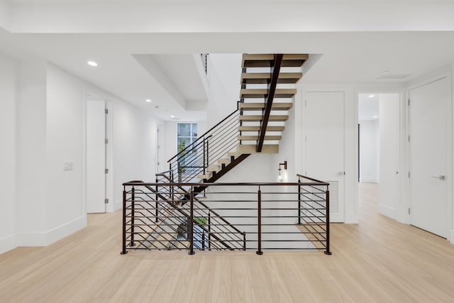 stairway with wood finished floors, recessed lighting, and baseboards