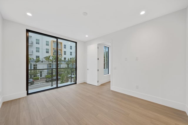 spare room with healthy amount of natural light, baseboards, light wood finished floors, and recessed lighting