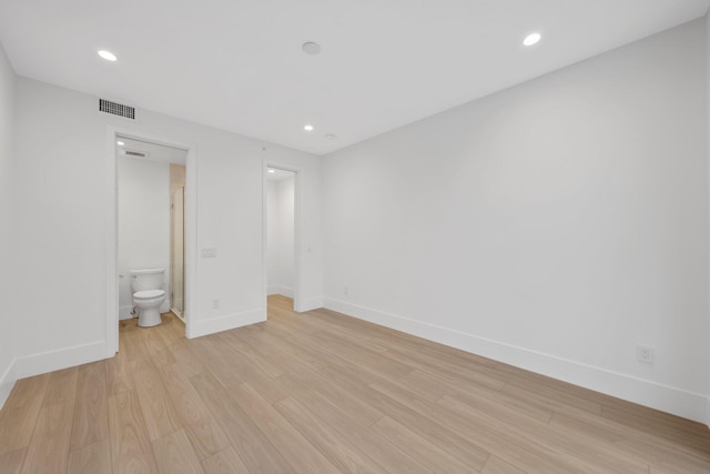 unfurnished bedroom with light wood finished floors, baseboards, recessed lighting, and connected bathroom
