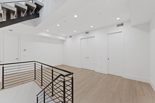 spare room featuring recessed lighting, wood finished floors, and baseboards