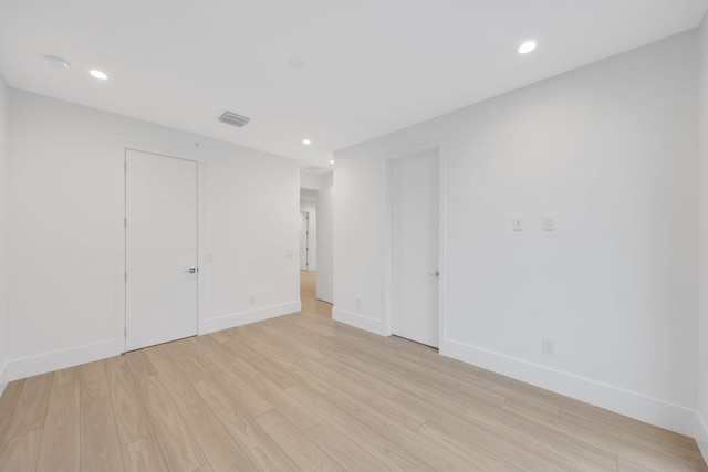 empty room with light wood-style floors, baseboards, and recessed lighting