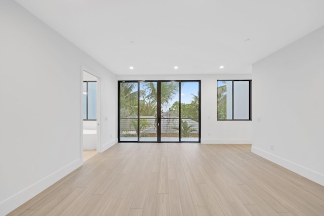 unfurnished room with baseboards, recessed lighting, and light wood-style flooring