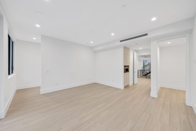 unfurnished room with light wood-style floors, recessed lighting, and baseboards