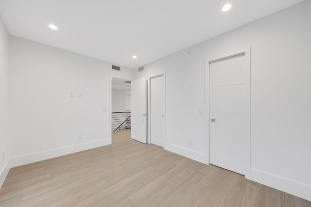 unfurnished bedroom featuring baseboards, light wood-style floors, and recessed lighting