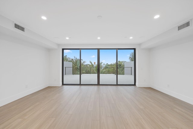 unfurnished room with baseboards, light wood finished floors, and recessed lighting