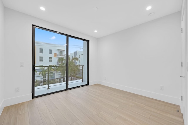empty room featuring light wood-style flooring, baseboards, recessed lighting, and a smoke detector