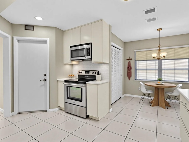 2710 SW 6th St SW, Boynton Beach, FL 33435 - kitchen with stainless steel appliances, light countertops, baseboards, tasteful backsplash, and pendant lighting