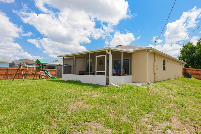 1222 SW Granadeer St, Port Saint Lucie, FL 34983 - rear view of house featuring a sunroom, a playground, stucco siding, and cooling unit
