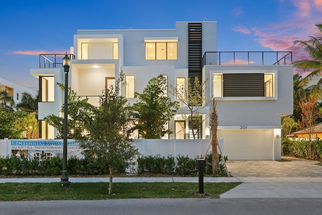 201 SE 4th Ave, Delray Beach, FL 33483 - modern home featuring a garage, stucco siding, and decorative driveway