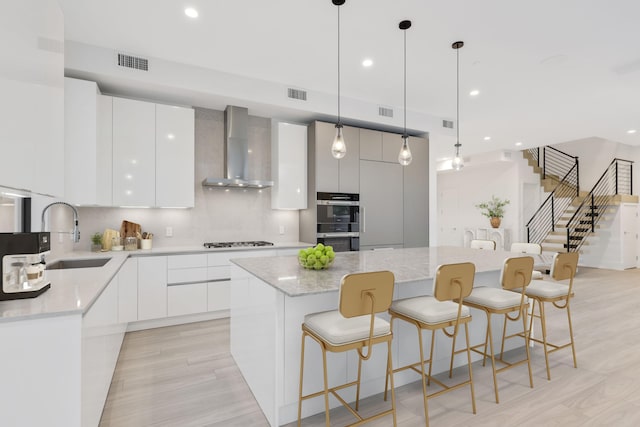 201 SE 4th Ave, Delray Beach, FL 33483 - kitchen with modern cabinets, wall chimney exhaust hood, a sink, and recessed lighting