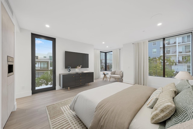 201 SE 4th Ave, Delray Beach, FL 33483 - bedroom featuring light wood-style flooring, access to exterior, and recessed lighting