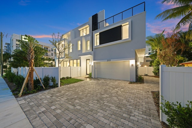 201 SE 4th Ave, Delray Beach, FL 33483 - contemporary house featuring an attached garage, stucco siding, and decorative driveway